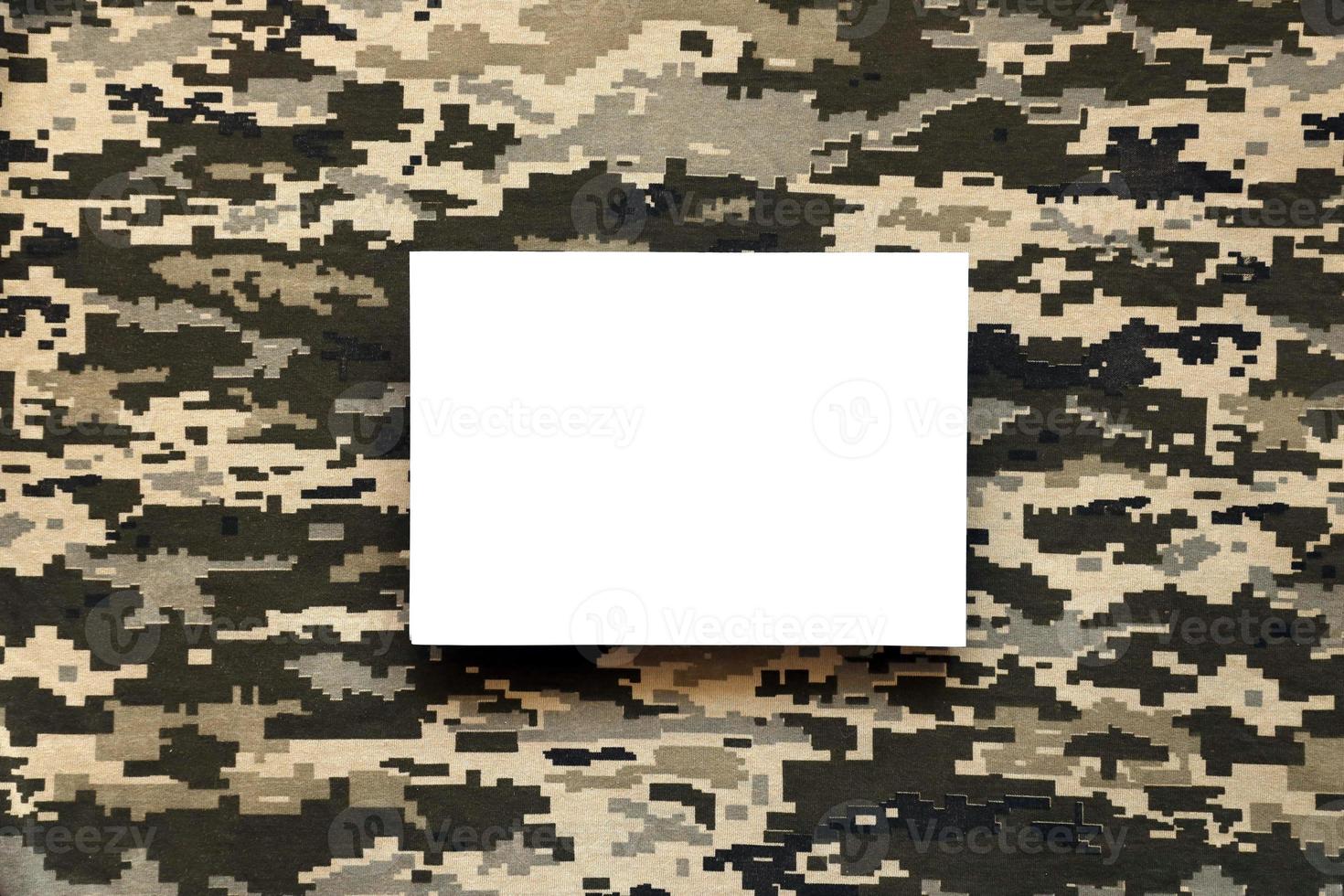 Fabric with texture of Ukrainian military pixeled camouflage and white blank paper. Cloth with camo pattern in grey, brown and green pixel shapes. photo
