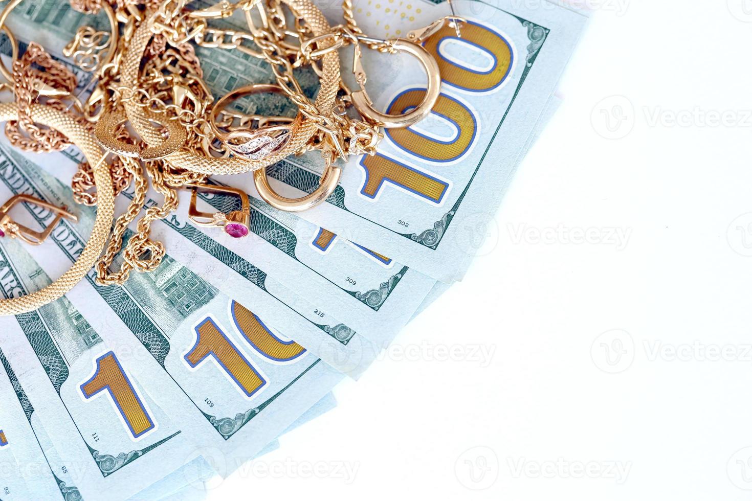 Many expensive golden jewerly rings, earrings and necklaces with big amount of US dollar bills on white background. Pawnshop or jewerly shop photo