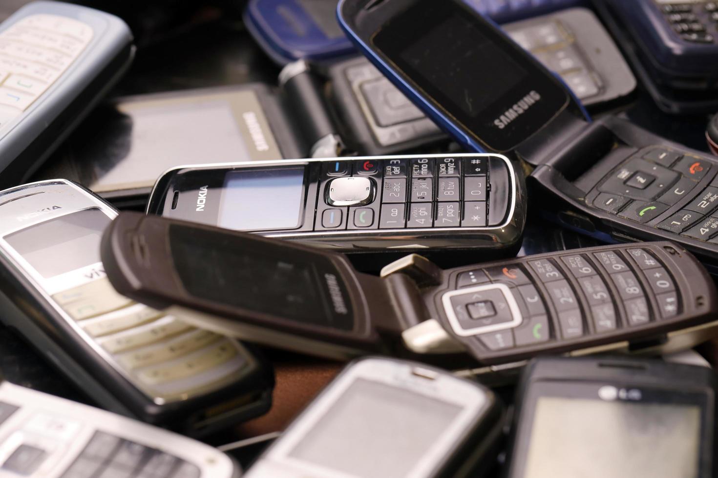 Some old used outdated mobile phones from 90s-2000s period. Recycling electronics in the market photo