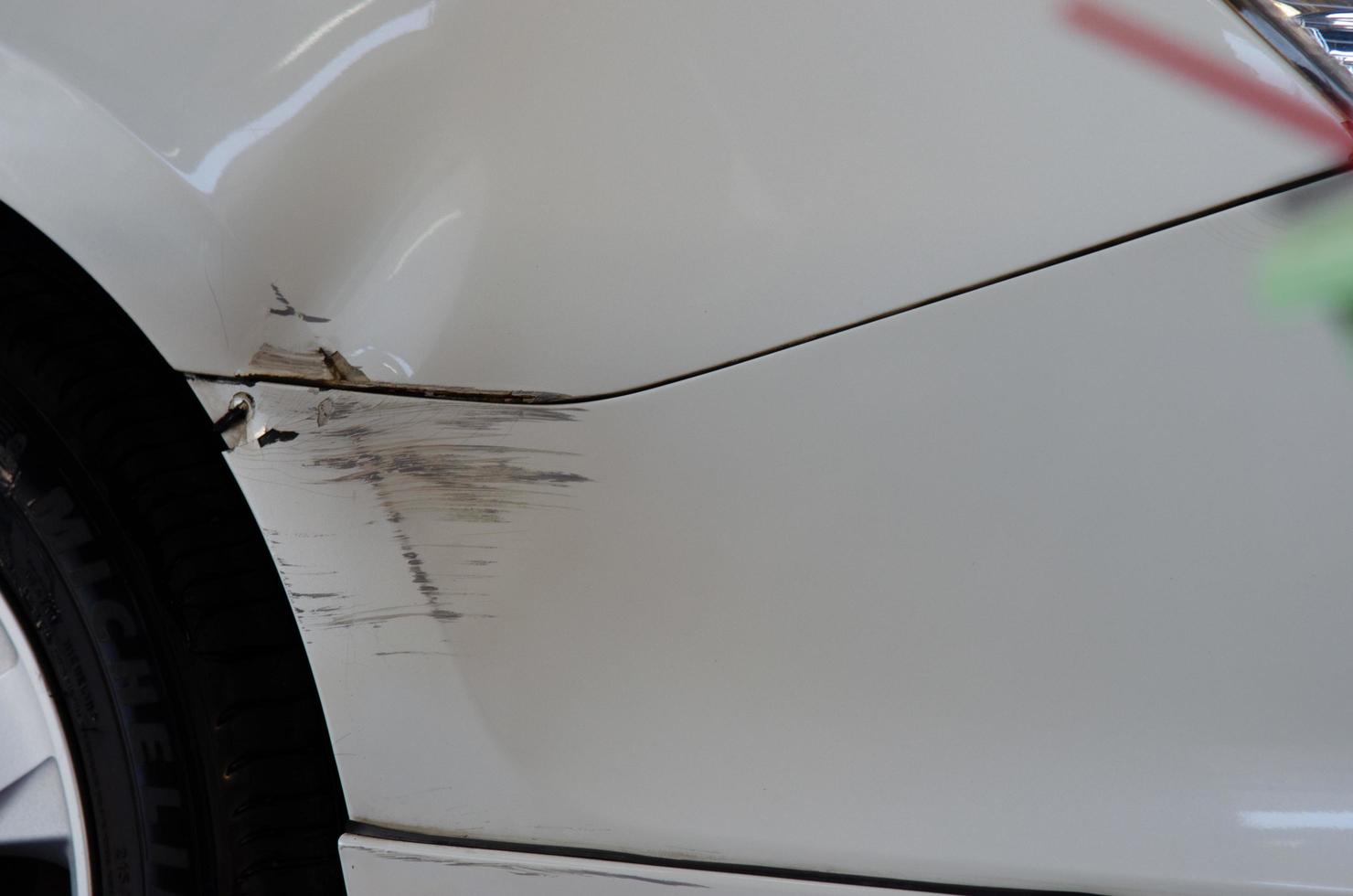 White car accident with abrasions. Concept car insurance business. photo