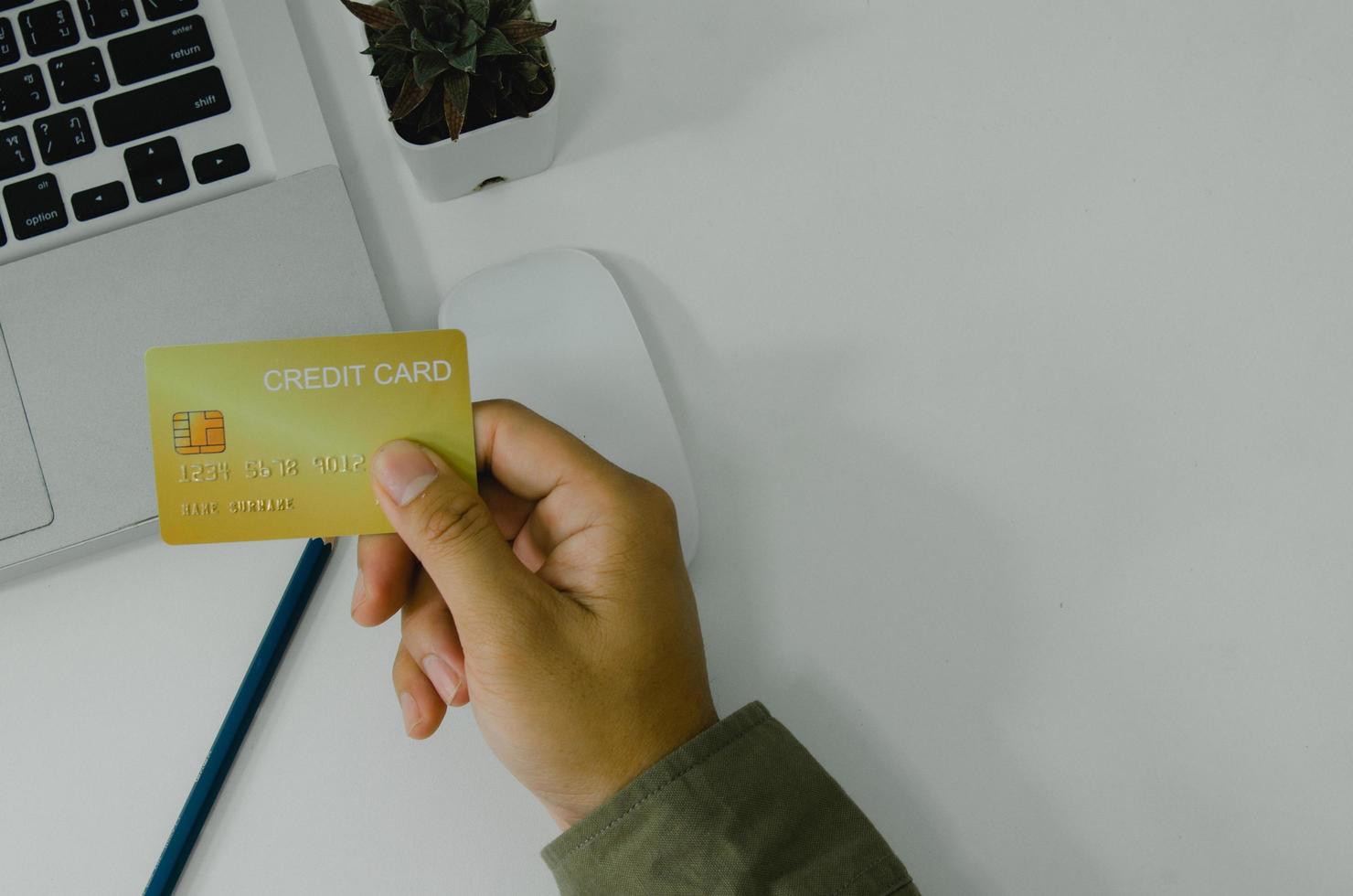 Man holding credit card business finance shopping online payment internet banking on background top view and fat lay. photo