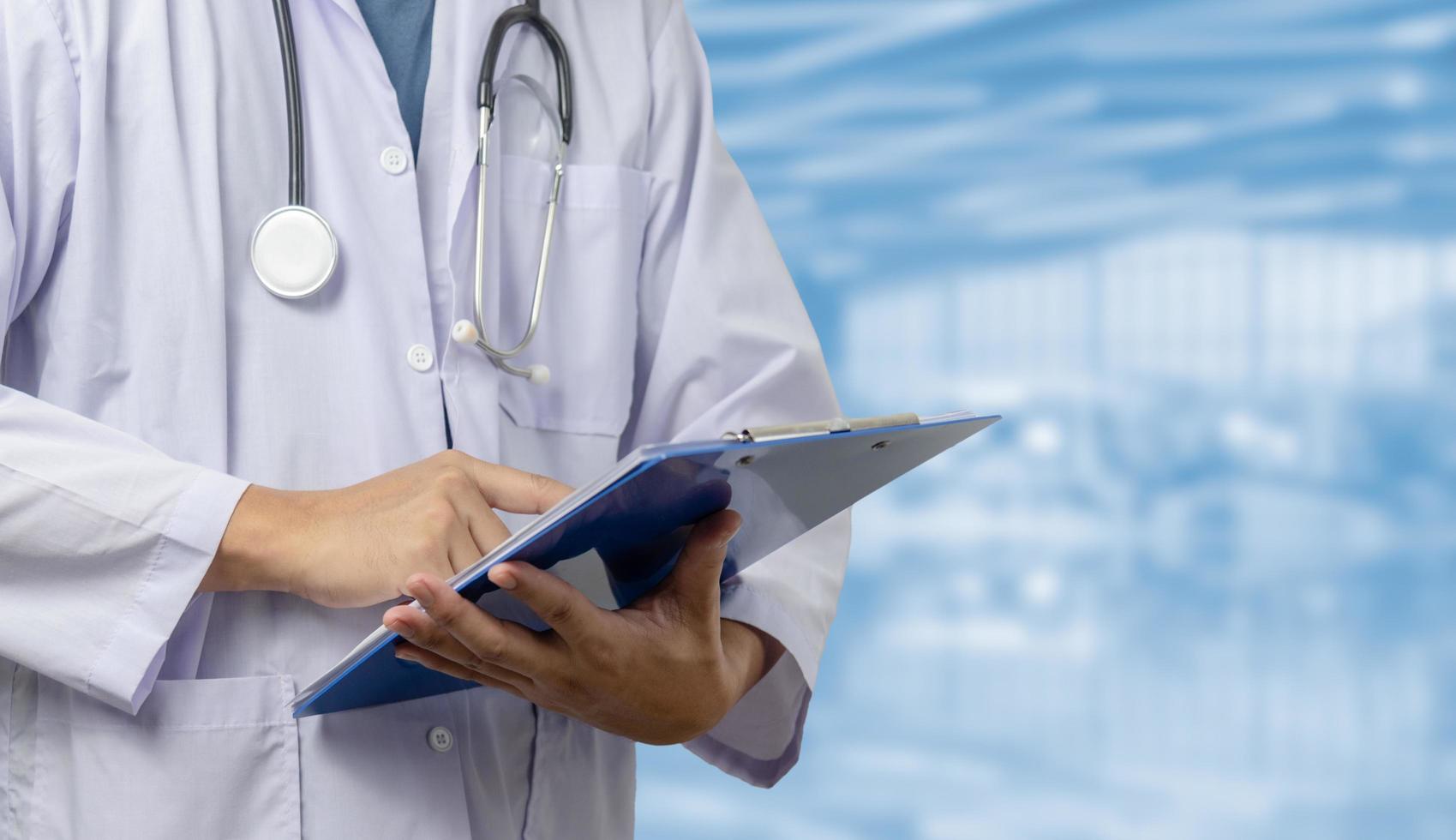 Doctor in a uniform, a stethoscope in a hospital corridor.Man holding document file health care concept.copy space photo