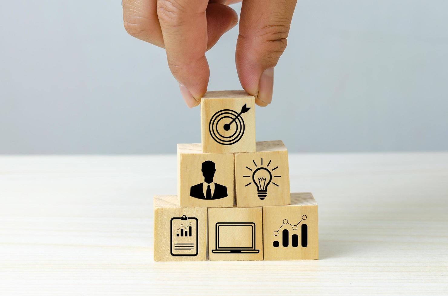 business strategy Action plan Goal and target icons with hand stack a wood cube block on a table. Copy space company development concept. photo