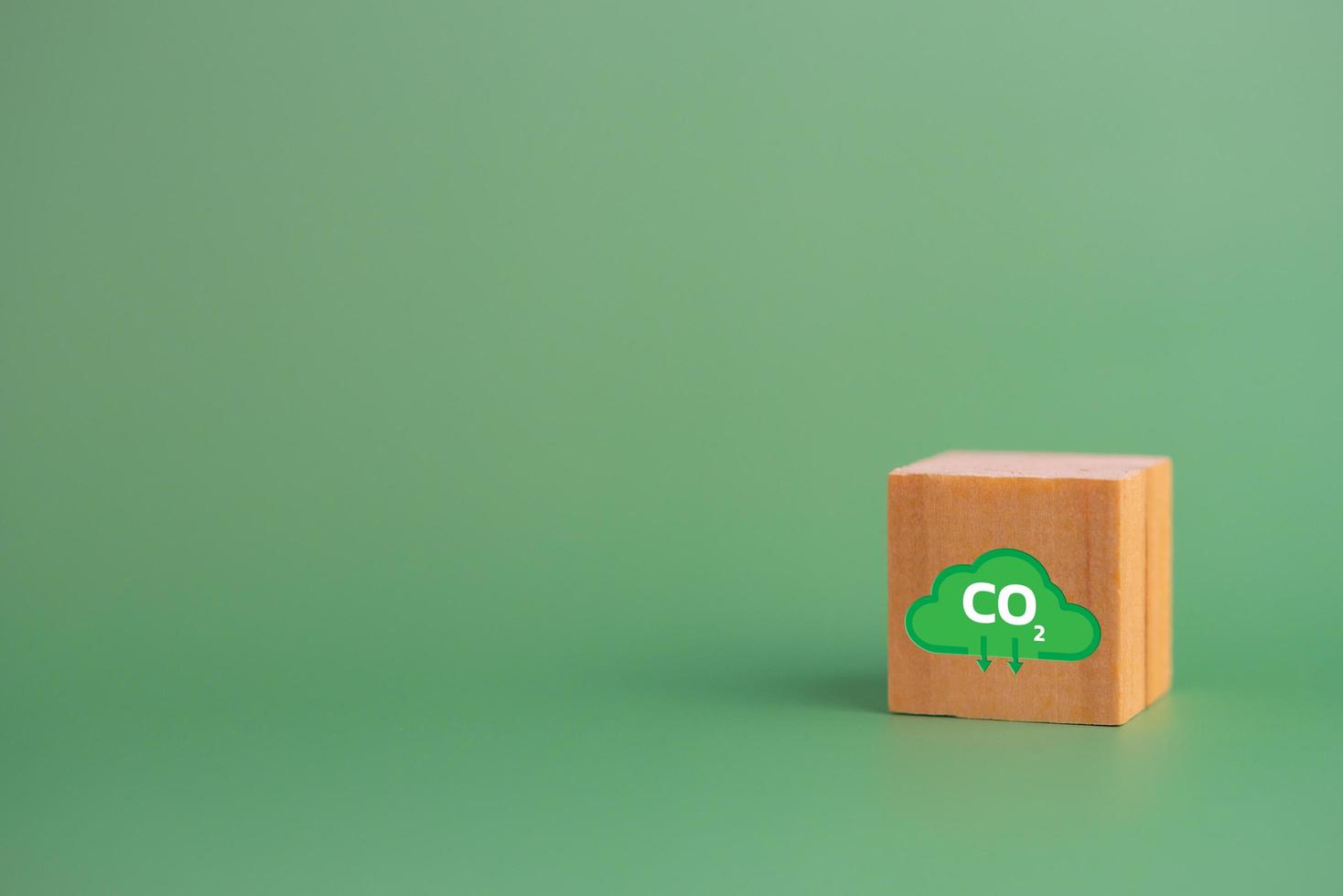 cero neto y crédito de carbono con icono de bloque de cubo de madera co2 eco sobre fondo verde. foto