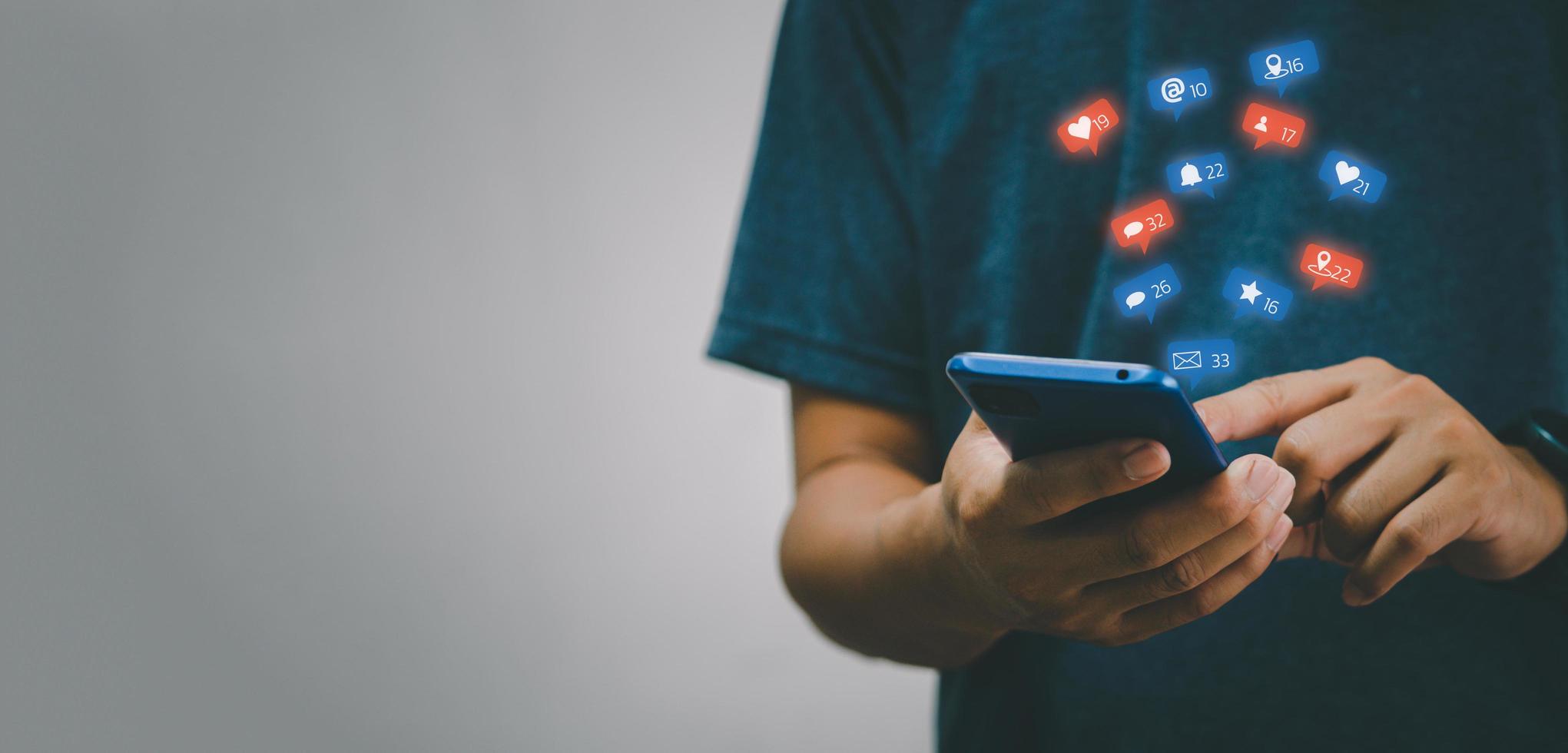 hombre que sostiene el icono en línea de las redes sociales de Internet de comunicación de red de tecnología digital de teléfono inteligente móvil en el espacio de copia de fondo. foto