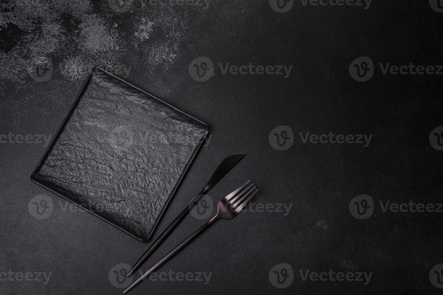 Empty square black plate on dark moody background with copy space photo