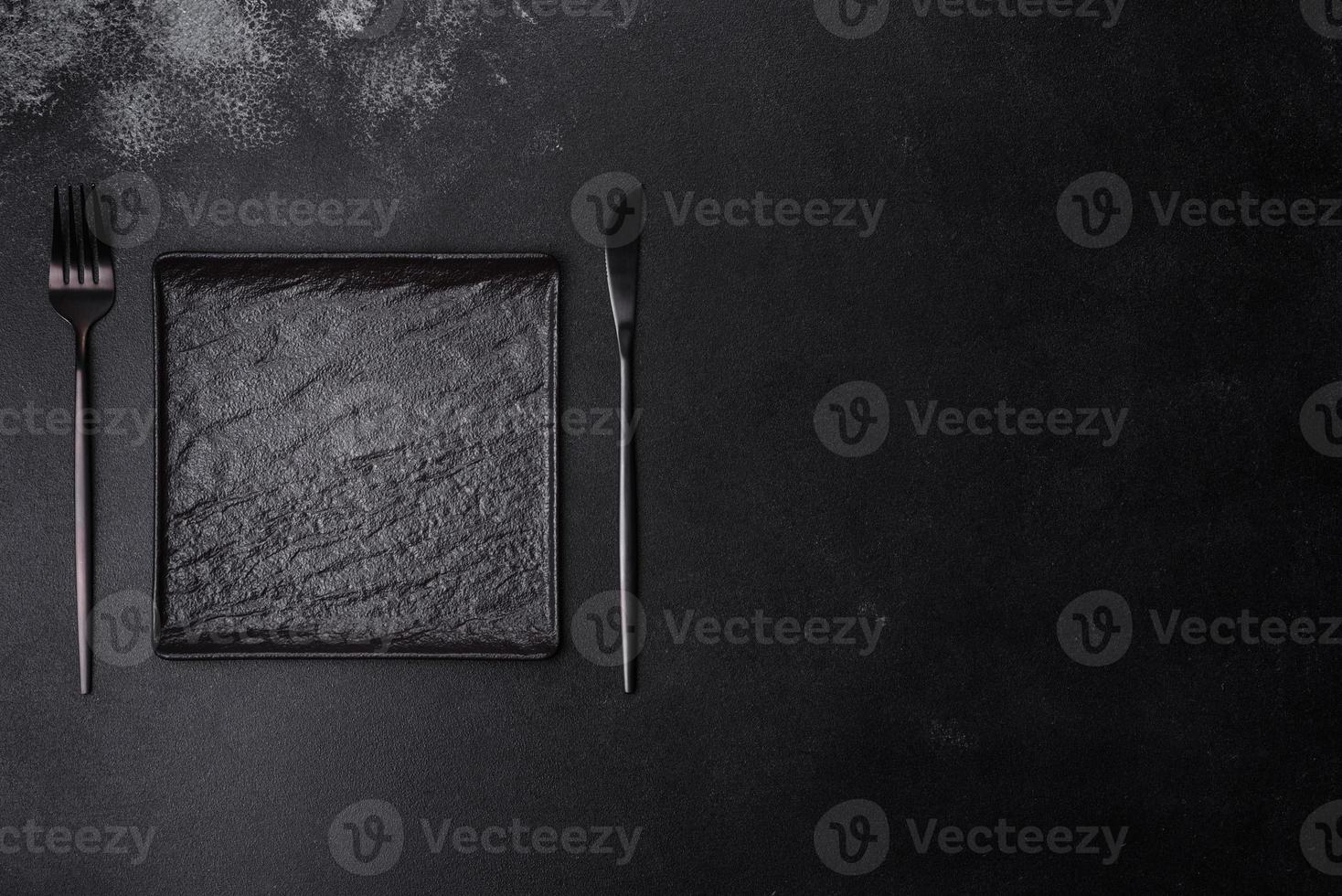 Empty square black plate on dark moody background with copy space photo