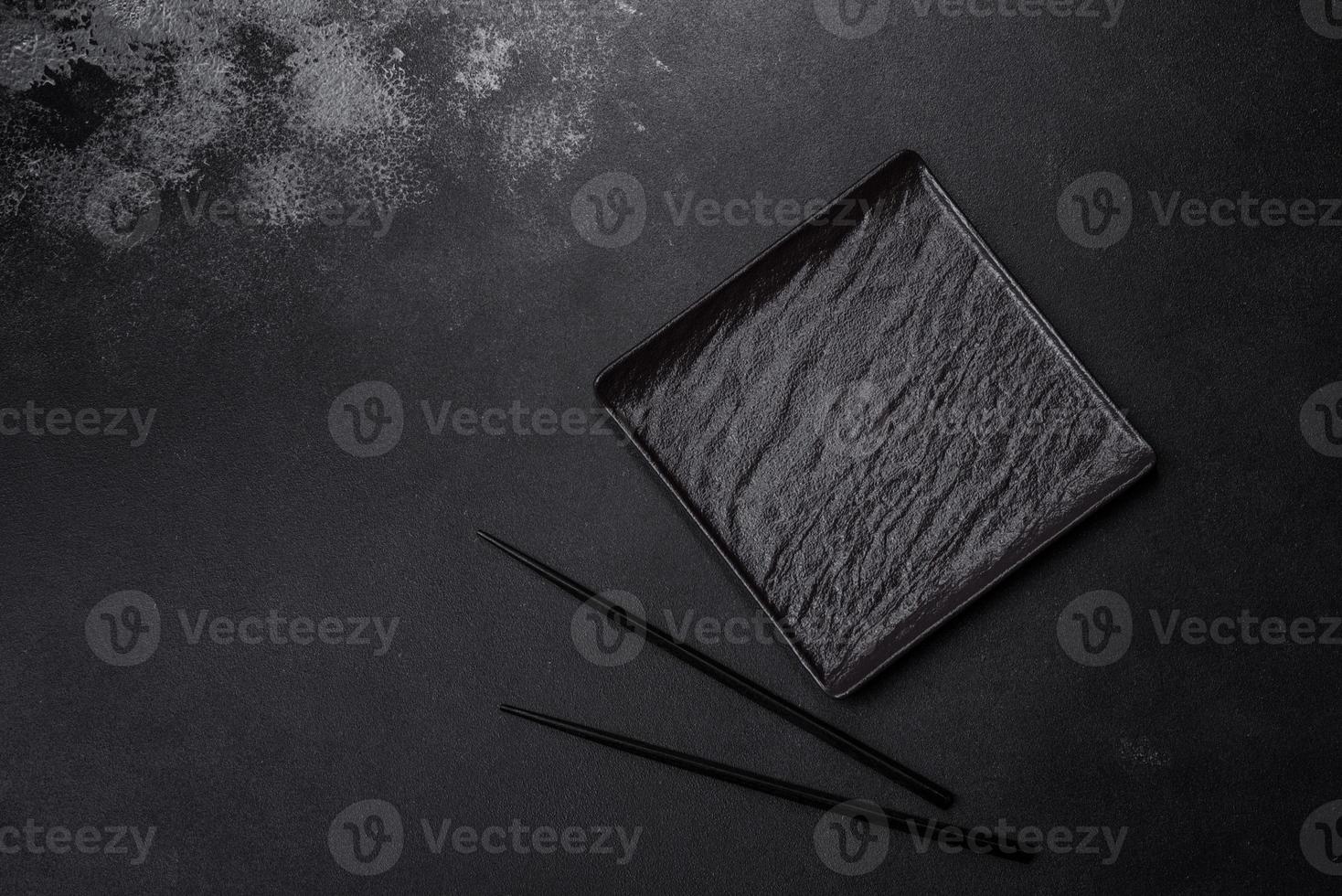 Empty square black plate on dark moody background with copy space photo
