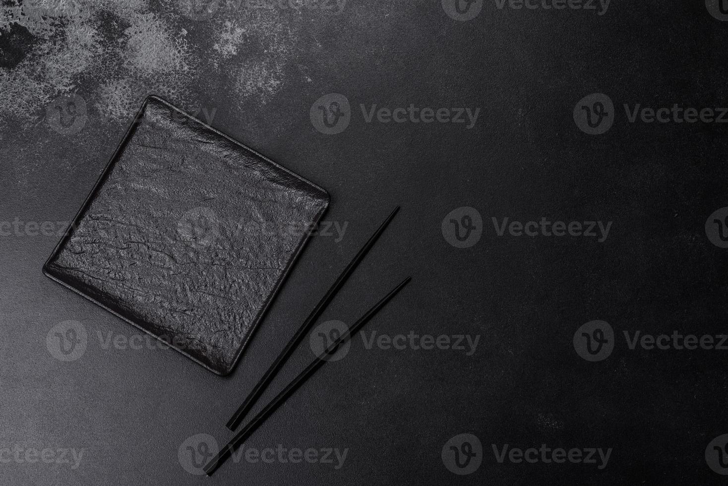 Empty square black plate on dark moody background with copy space photo