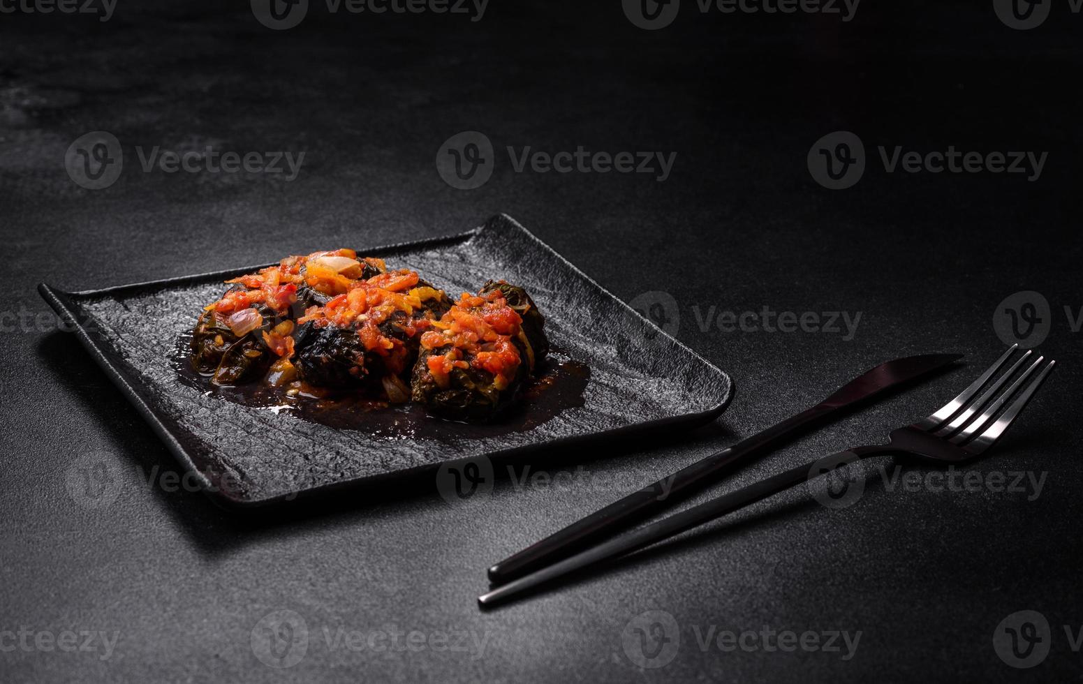 Dolma, stuffed grape leaves with rice and meat on a dark background photo