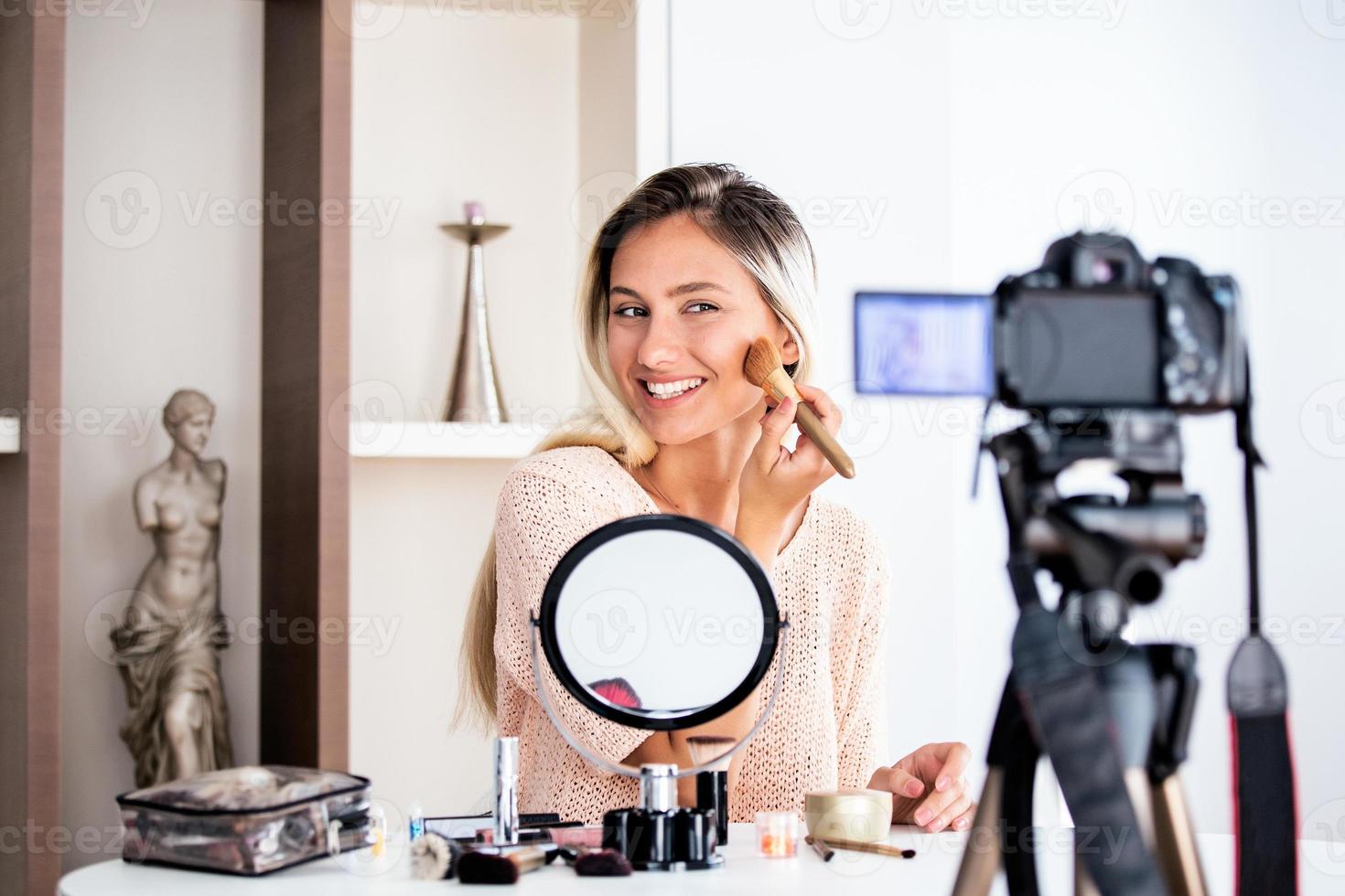 hermosa joven bloguera grabando video vlog con maquillaje cosmético en casa influenciador en línea en el concepto de redes sociales. transmisión en vivo viral foto