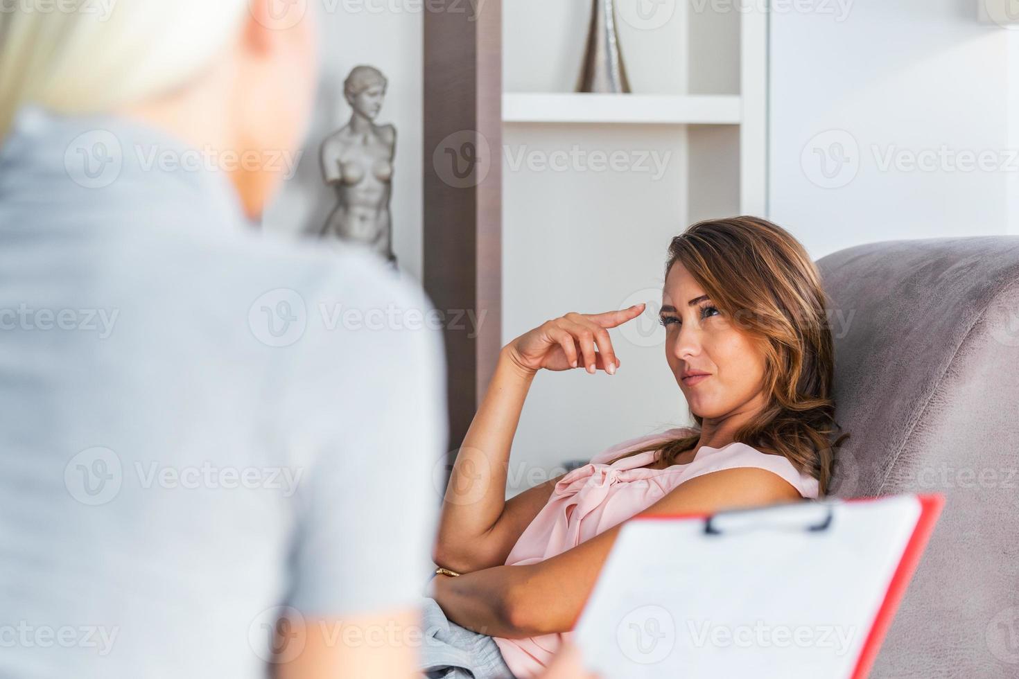 Woman at therapy session. Attentive psychologist. Young woman at psychotherapy thinking about advice she received photo