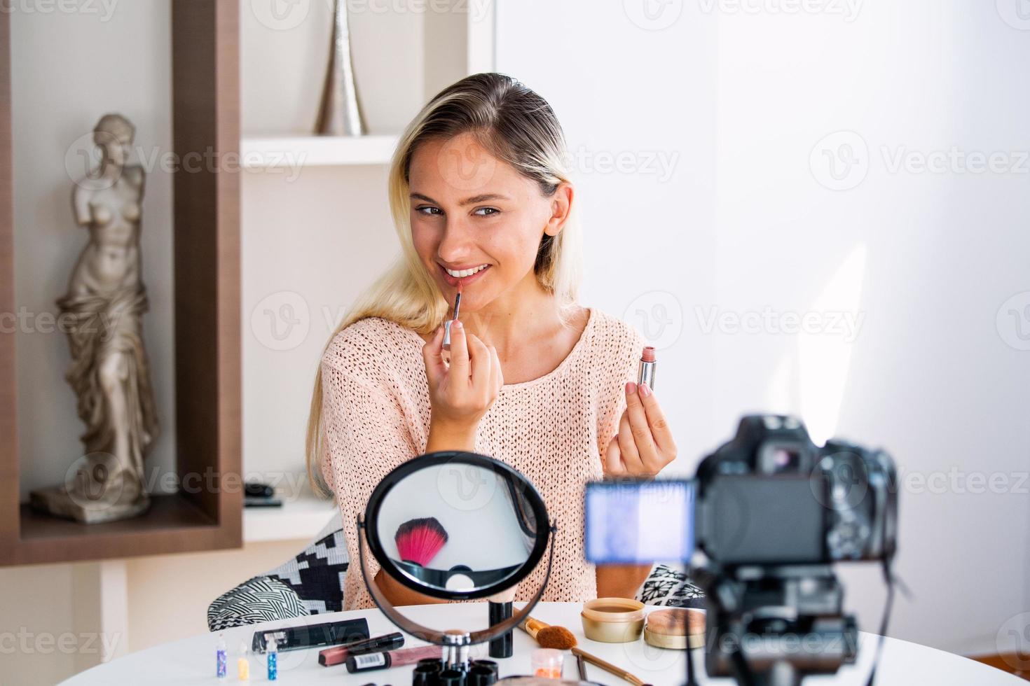 hermosa joven bloguera grabando video vlog con maquillaje cosmético en casa influenciador en línea en el concepto de redes sociales. transmisión en vivo viral foto