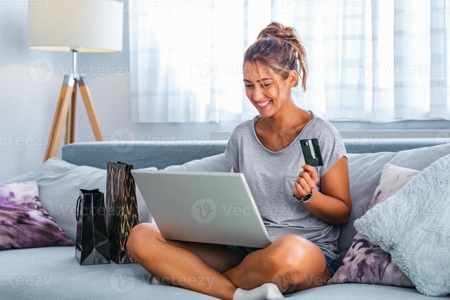 imagen que muestra a una mujer bonita comprando en línea con tarjeta de crédito. mujer con tarjeta de crédito y usando laptop. concepto de compras en línea foto