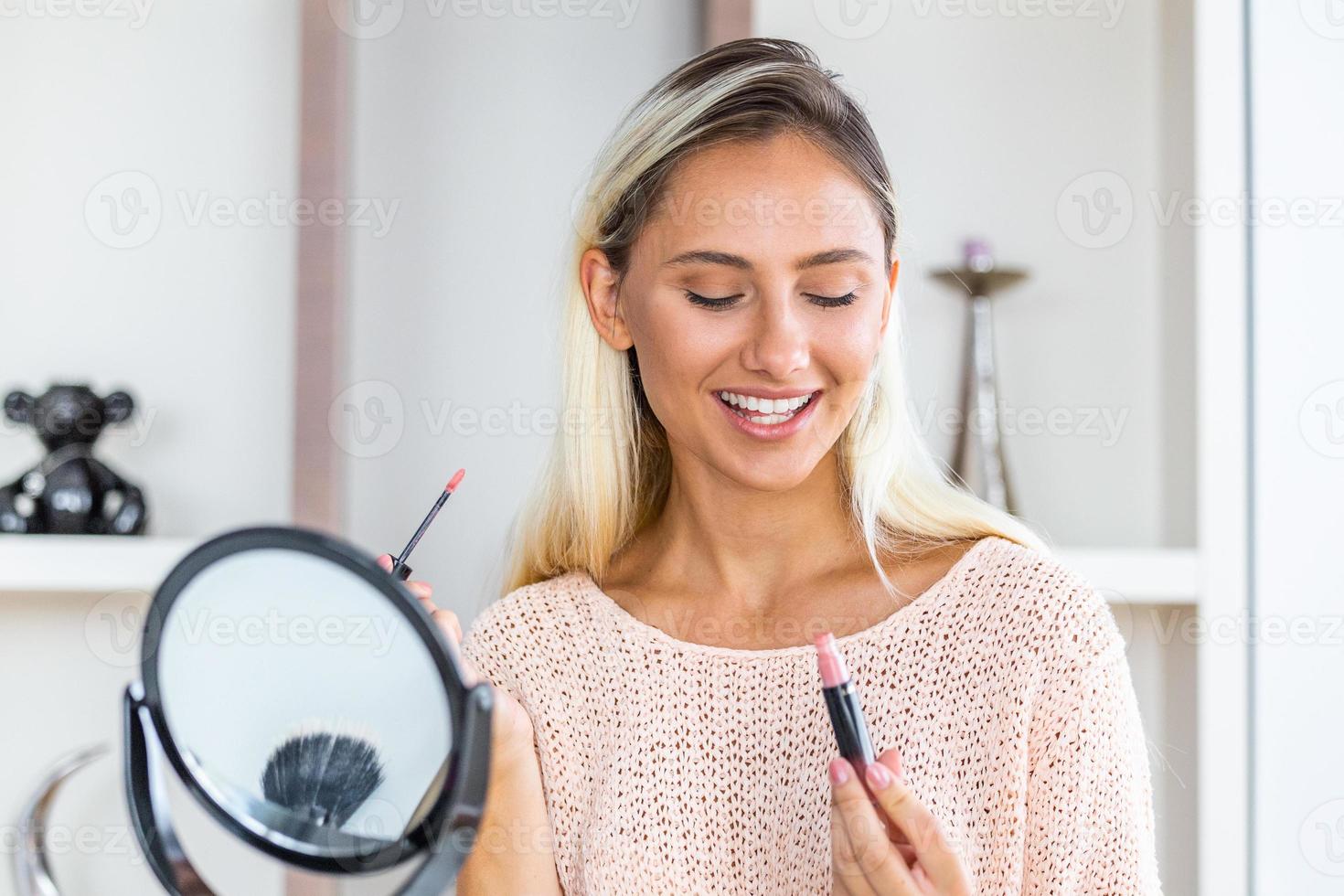 mujer aplicando rímel negro en las pestañas con pincel de maquillaje. maquillaje de belleza. retrato de una hermosa joven aplicando rímel negro en las pestañas, sosteniendo un cepillo en la mano. foto