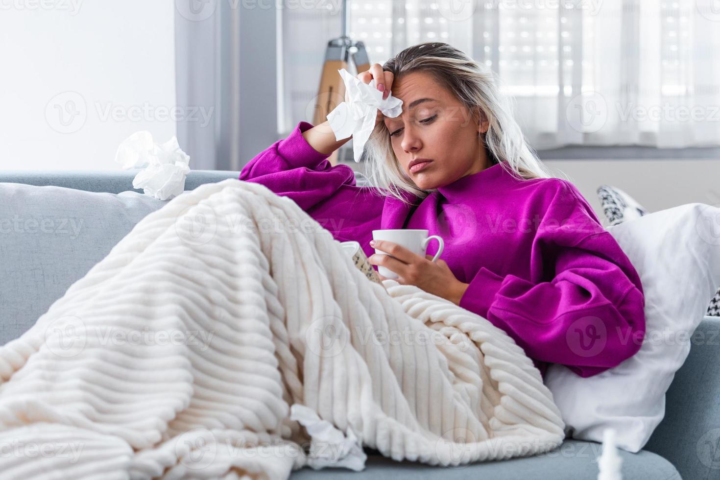 resfriado y gripe. retrato de una mujer enferma resfriada, sintiéndose enferma y bebiendo bebidas calientes. primer plano de una hermosa niña malsana cubierta de manta limpiándose la nariz. concepto de salud. foto