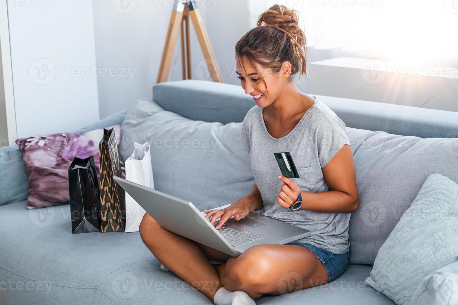 imagen que muestra a una mujer bonita comprando en línea con tarjeta de crédito. mujer con tarjeta de crédito y usando laptop. concepto de compras en línea foto