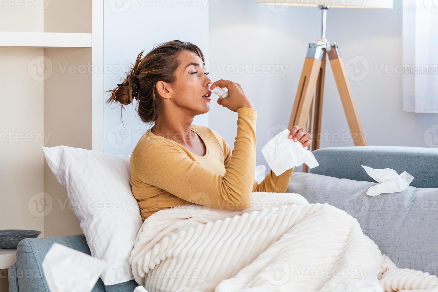 Woman is having flu and she is using nasal spray to help herself. Woman using nasal spray. Nasal spray to help a cold. Sick with a rhinitis woman dripping nose. Woman applies nasal spray photo