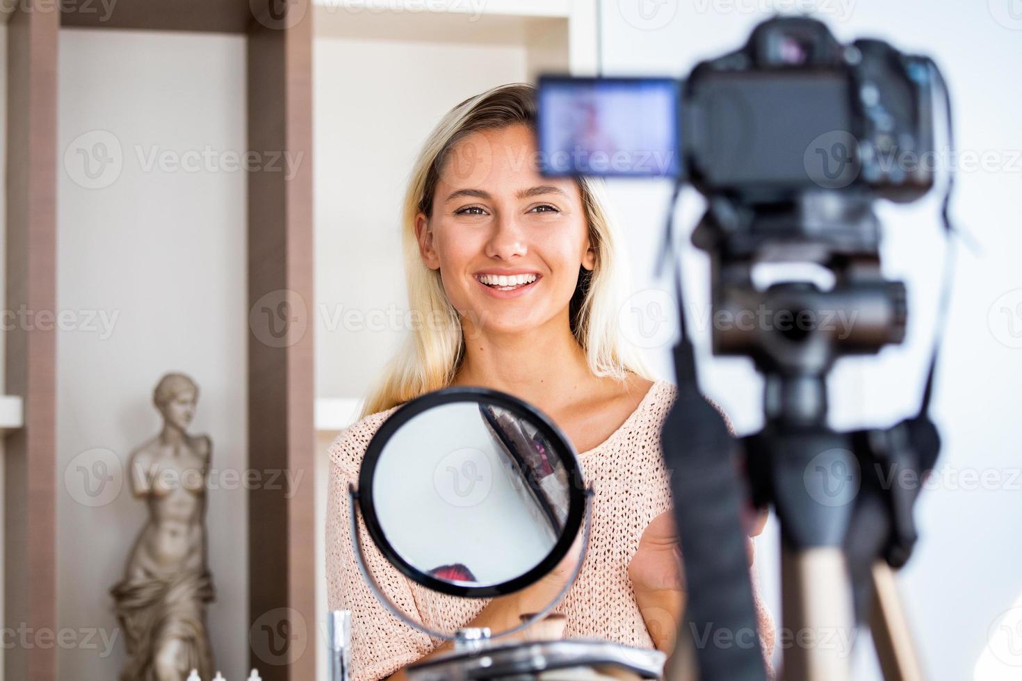 Beautiful young female blogger recording vlog video with makeup cosmetic at home online influencer on social media concept.live streaming viral photo