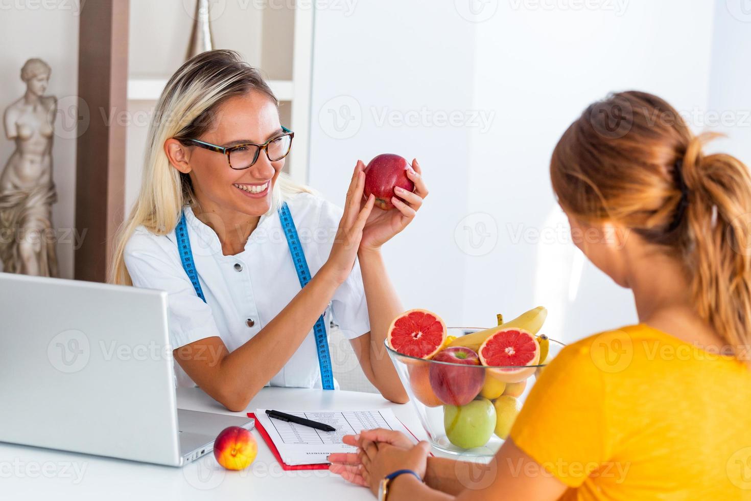 Doctor nutritionist, dietician and female patient on consultation in the office. Female nutritionist giving consultation to patient. Making diet plan. photo