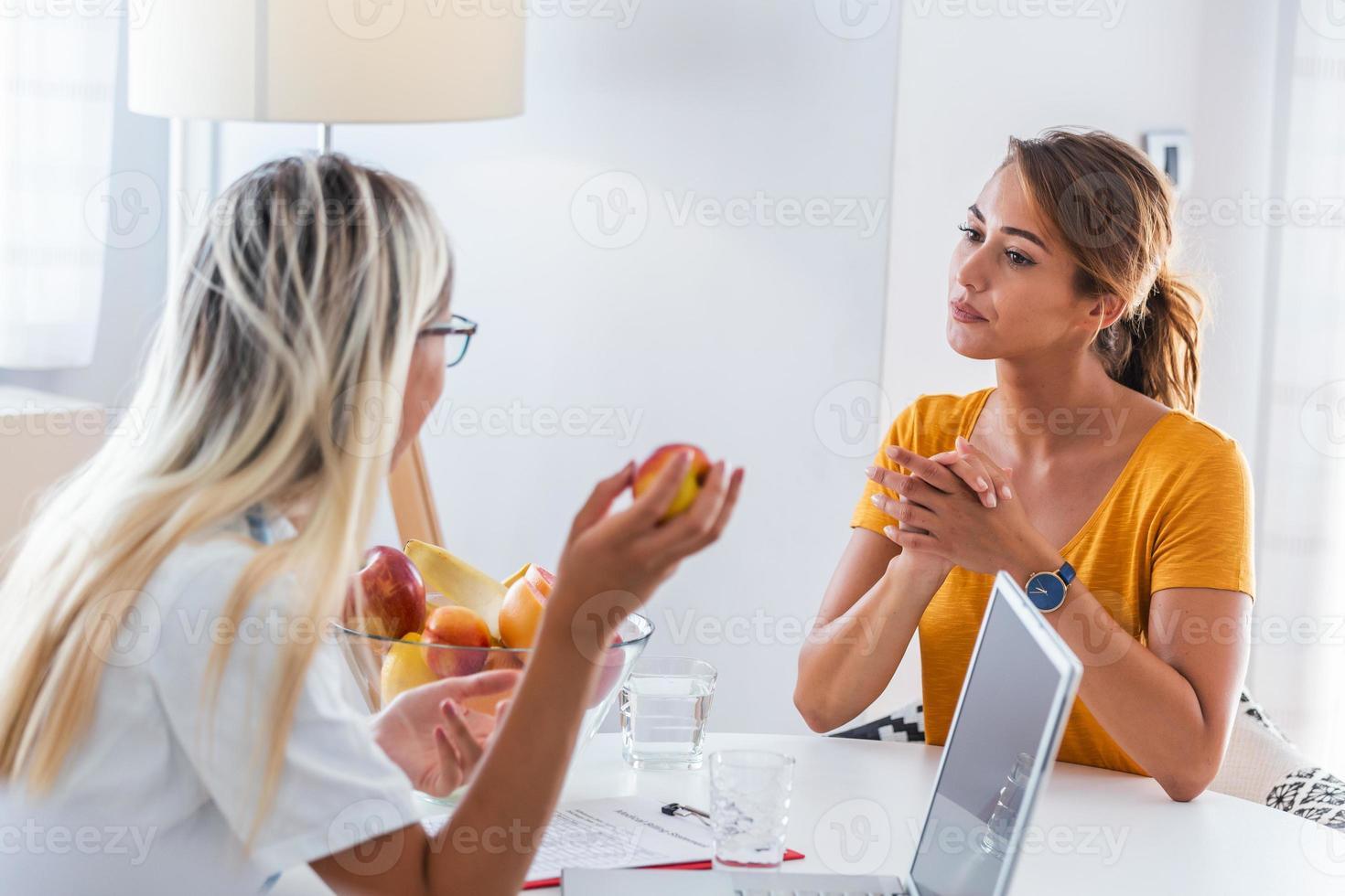 Doctor nutritionist, dietician and female patient on consultation in the office. Making diet plan. Young woman visiting nutritionist in weight loss clinic photo