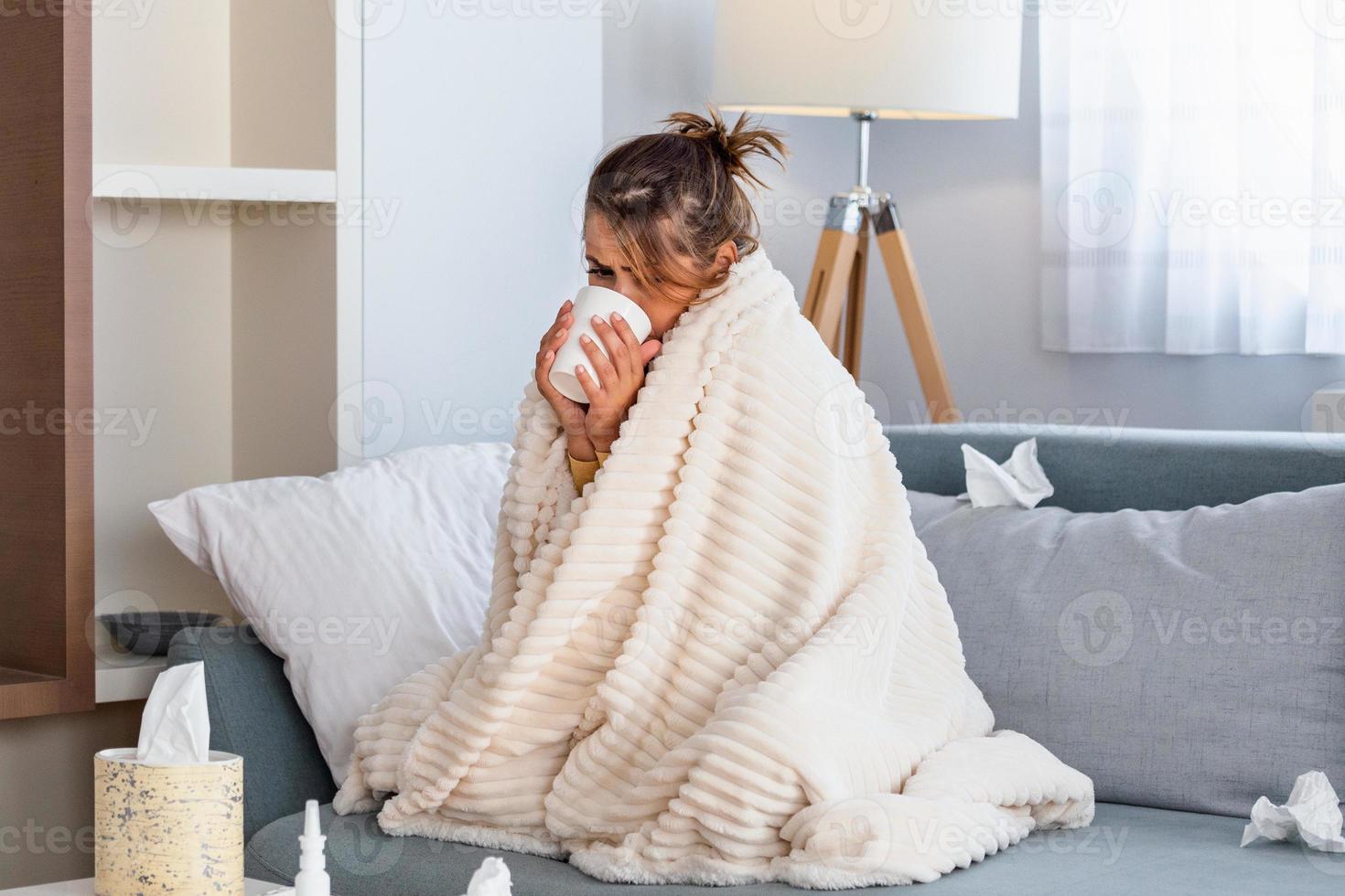 Cold And Flu. Portrait Of Ill Woman Caught Cold, Feeling Sick And Sneezing In Paper Wipe. Closeup Of Beautiful Unhealthy Girl Covered In Blanket Wiping Nose. Healthcare Concept. photo