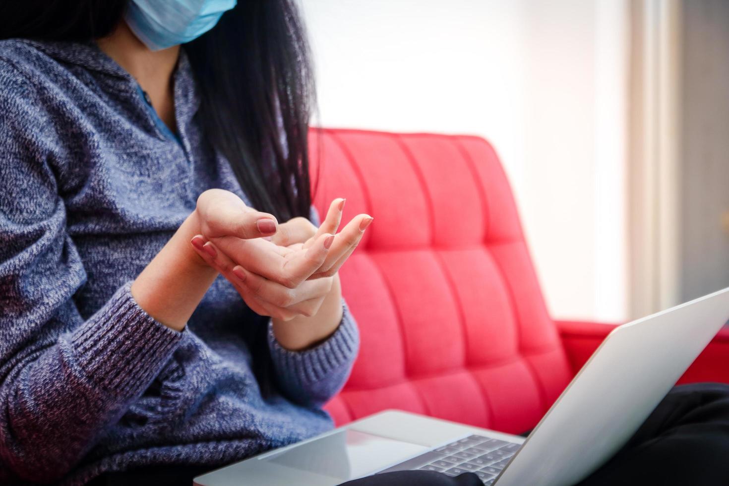 Asian woman wearing a mask works at home during the coronavirus Massage the fingers to get rid of the pain. Because she works all day. The concept of social distance. Office Syndrome Health Problems photo