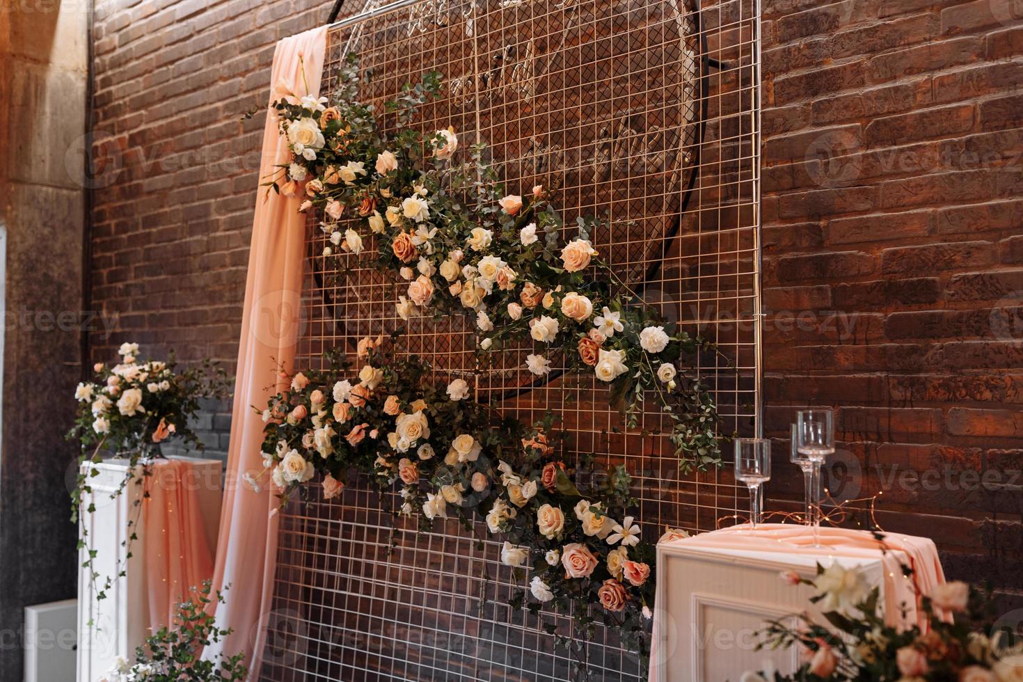 Wedding decor. Photographic area is a stylish wedding decoration. Decorated with flowers, mini florals. Wedding photo zone with flowers. Hand made wedding decorations. Place for taking pictures