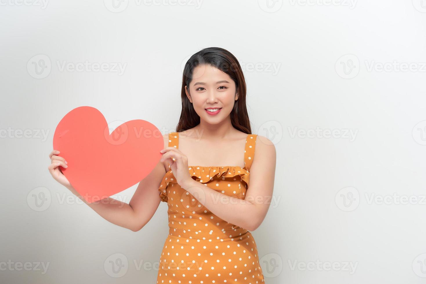 Love and valentines day. Sexy woman in polka dot dress holding heart smiling cute and adorable photo