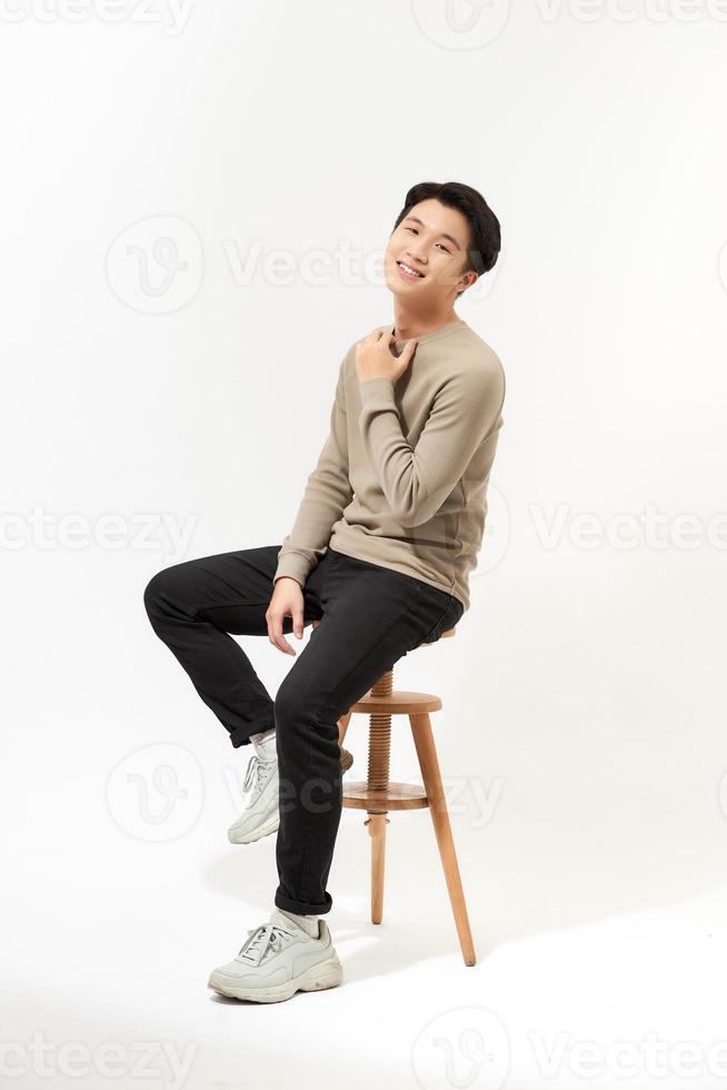 Full body Asian man sitting on high chair over white background photo