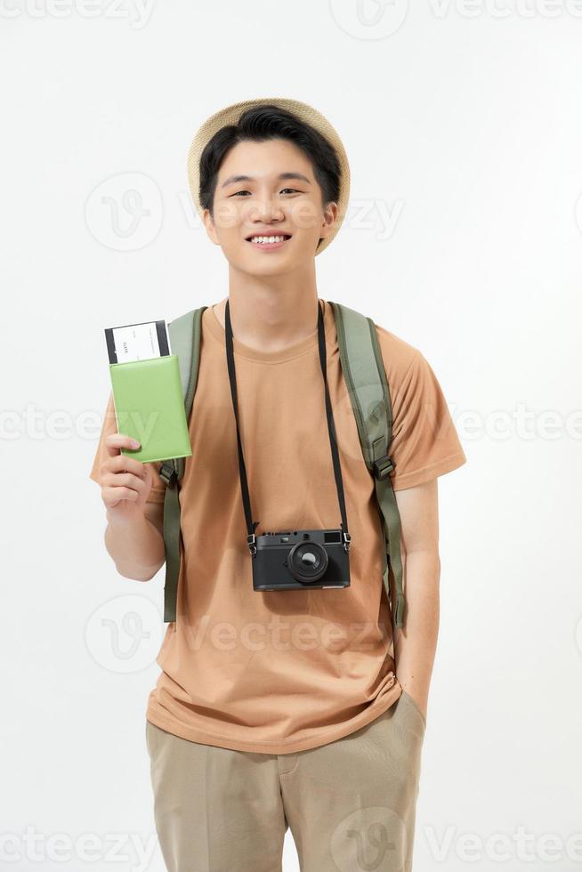 Young man with suitcase, camera and ticket on white background photo