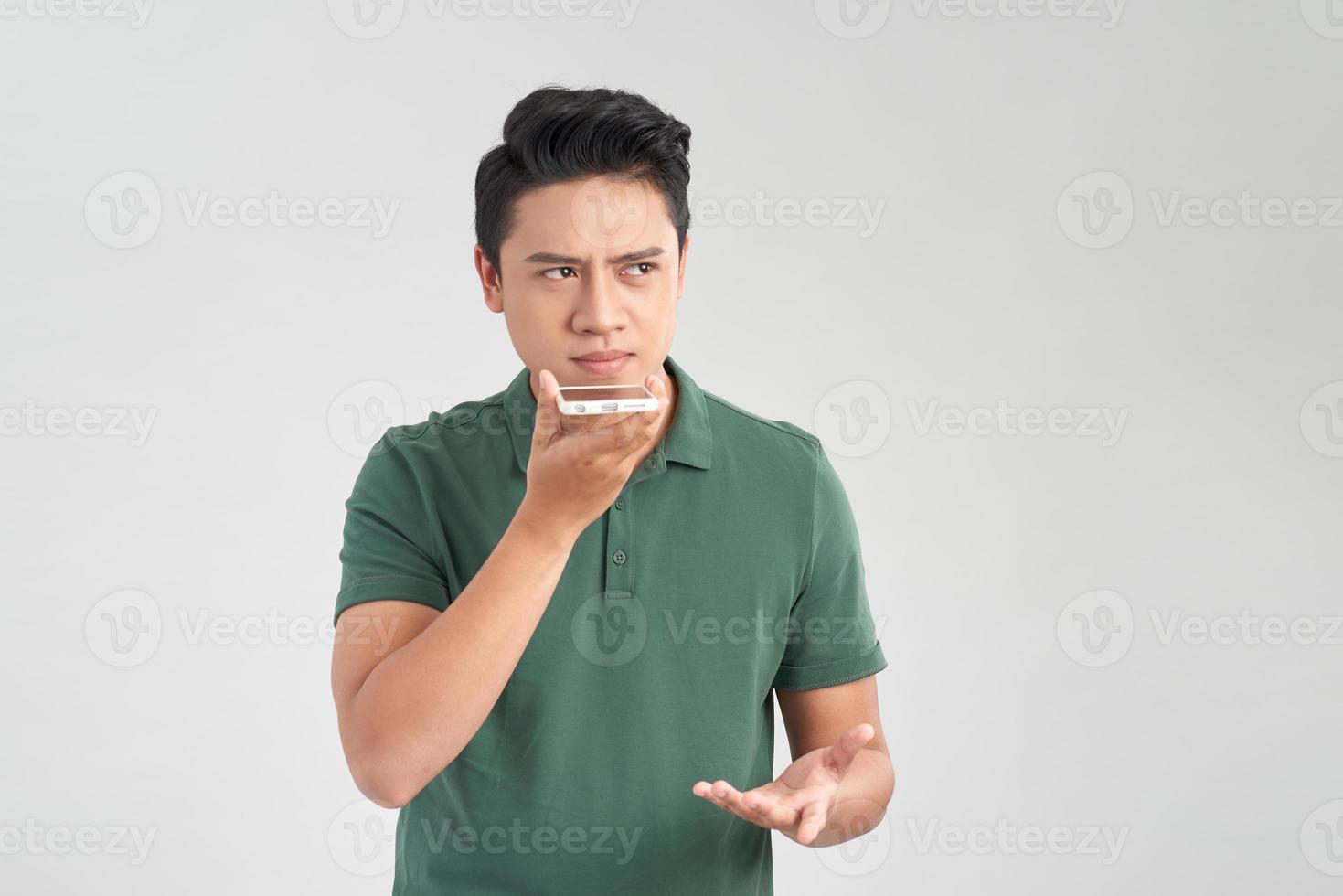 You will have problems man. Portrait of angry confused aggressive in bad mood guy talking in the loudspeaker of his smartphone, isolated on white background photo