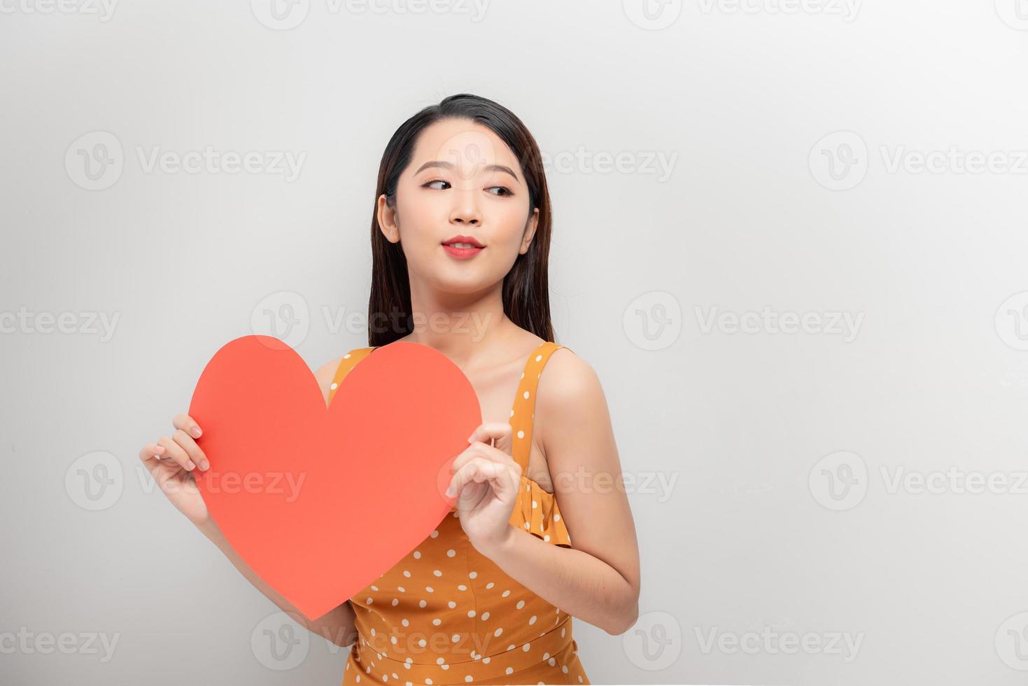 Woman holding big red heart on white background photo
