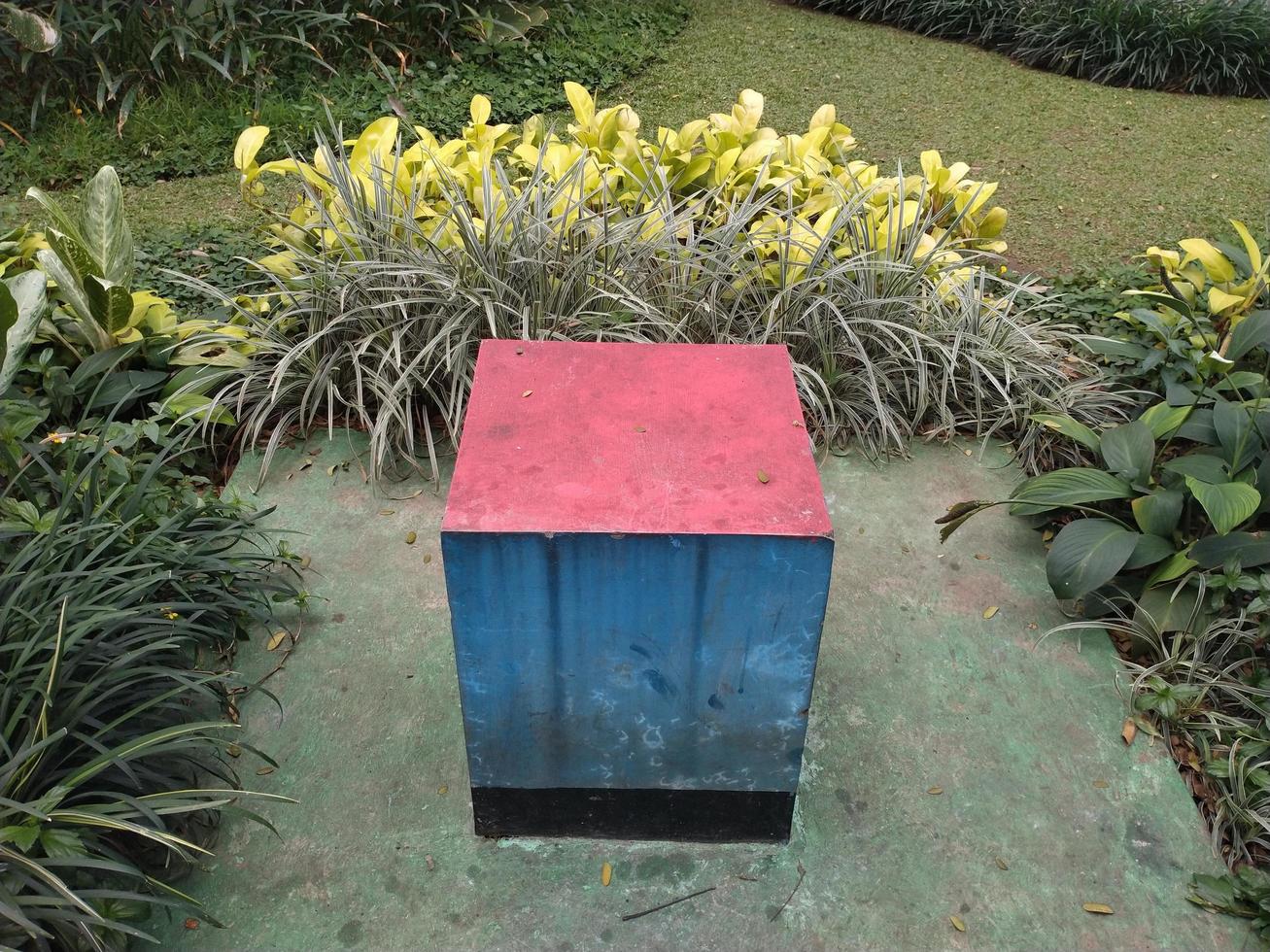 public facility, a cement box seat with blue and red color in a park photo
