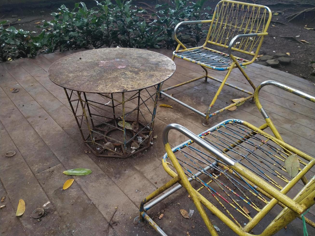 rusty iron chairs and tables on the terrace in a shady ambience. This photo can be used for everything related to nature, exterior, terrace, house and residence, plants, garden, backyard