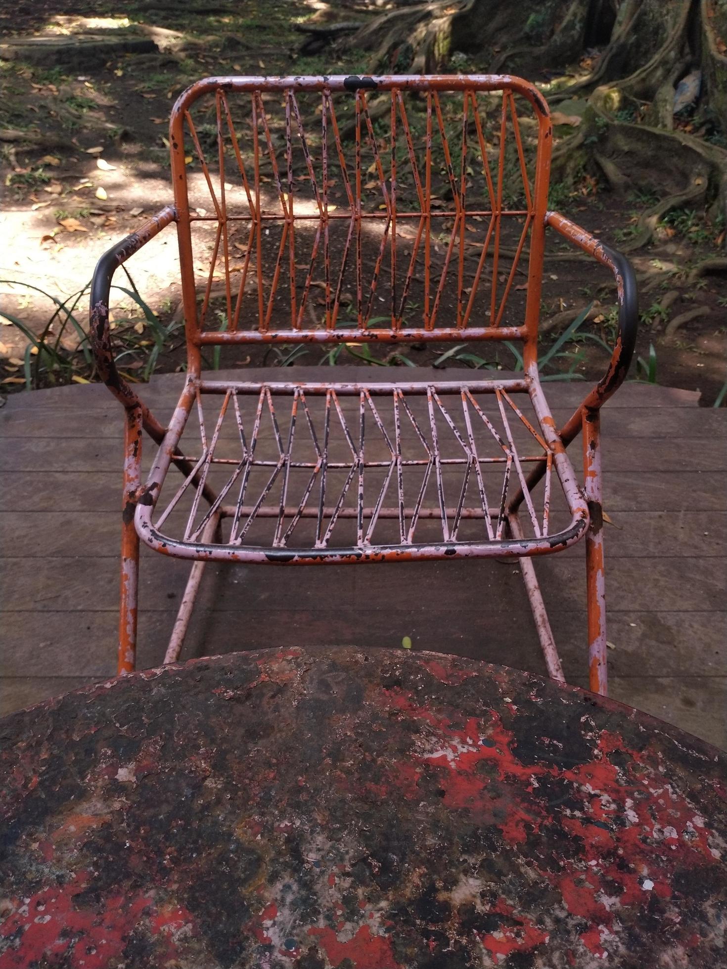 rusty iron chairs and tables on the terrace in a shady ambience. This