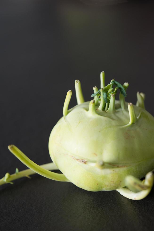 Vertical shot of a kohlrabi. Close up with black background photo
