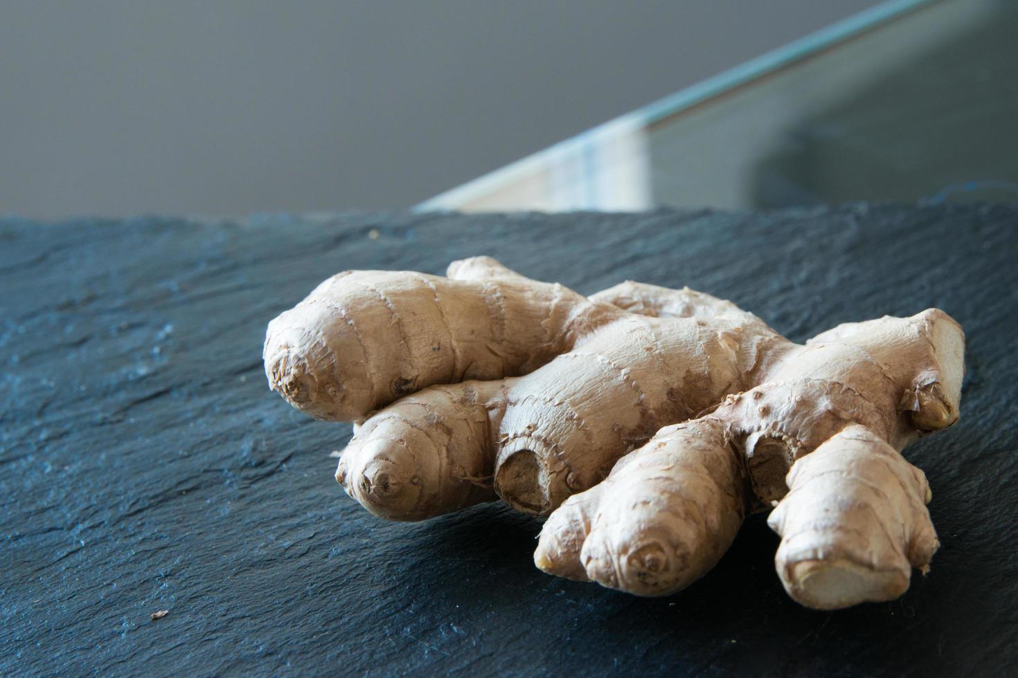 Fresh ginger root on a black kitchen counter. photo