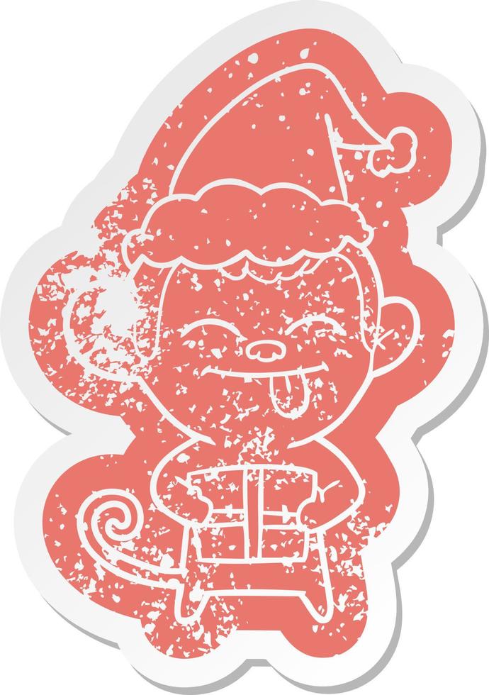 funny cartoon distressed sticker of a monkey with christmas present wearing santa hat vector