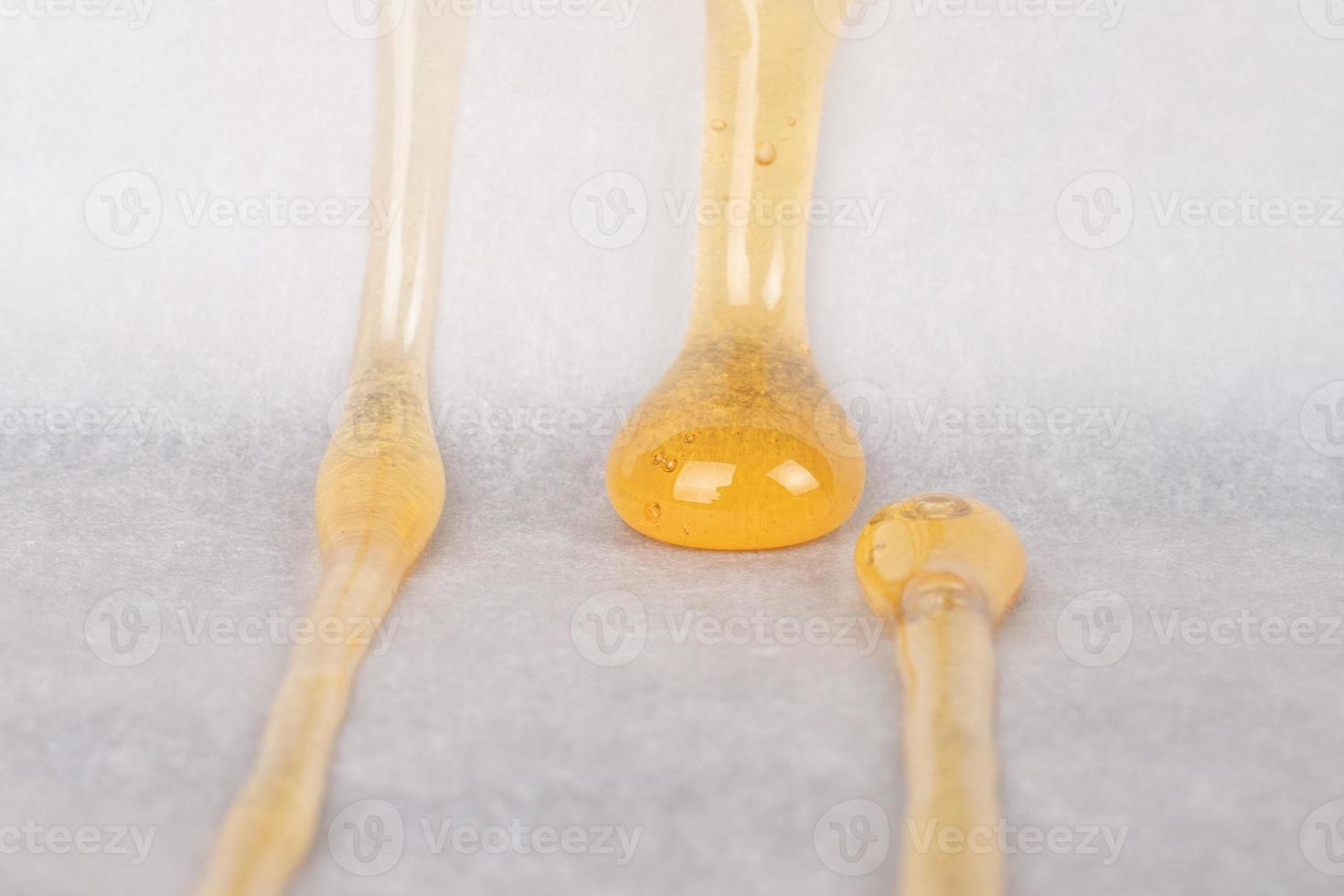 dripping drops of yellow cannabis wax with a high content of thc on paper photo