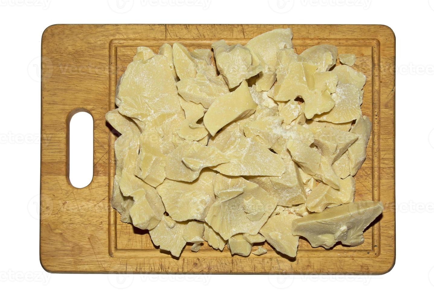 Pieces of cocoa butter on a wooden board. Cocoa butter is an ingredient for making chocolate. Chunks of cocoa butter before grinding. photo