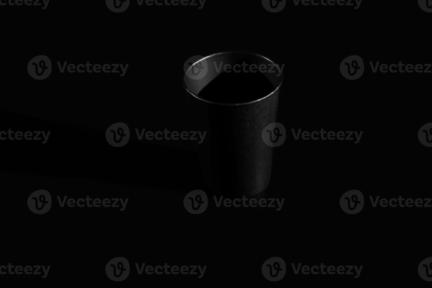 black paper glass isolated on black background. a glass for tea or coffee photo