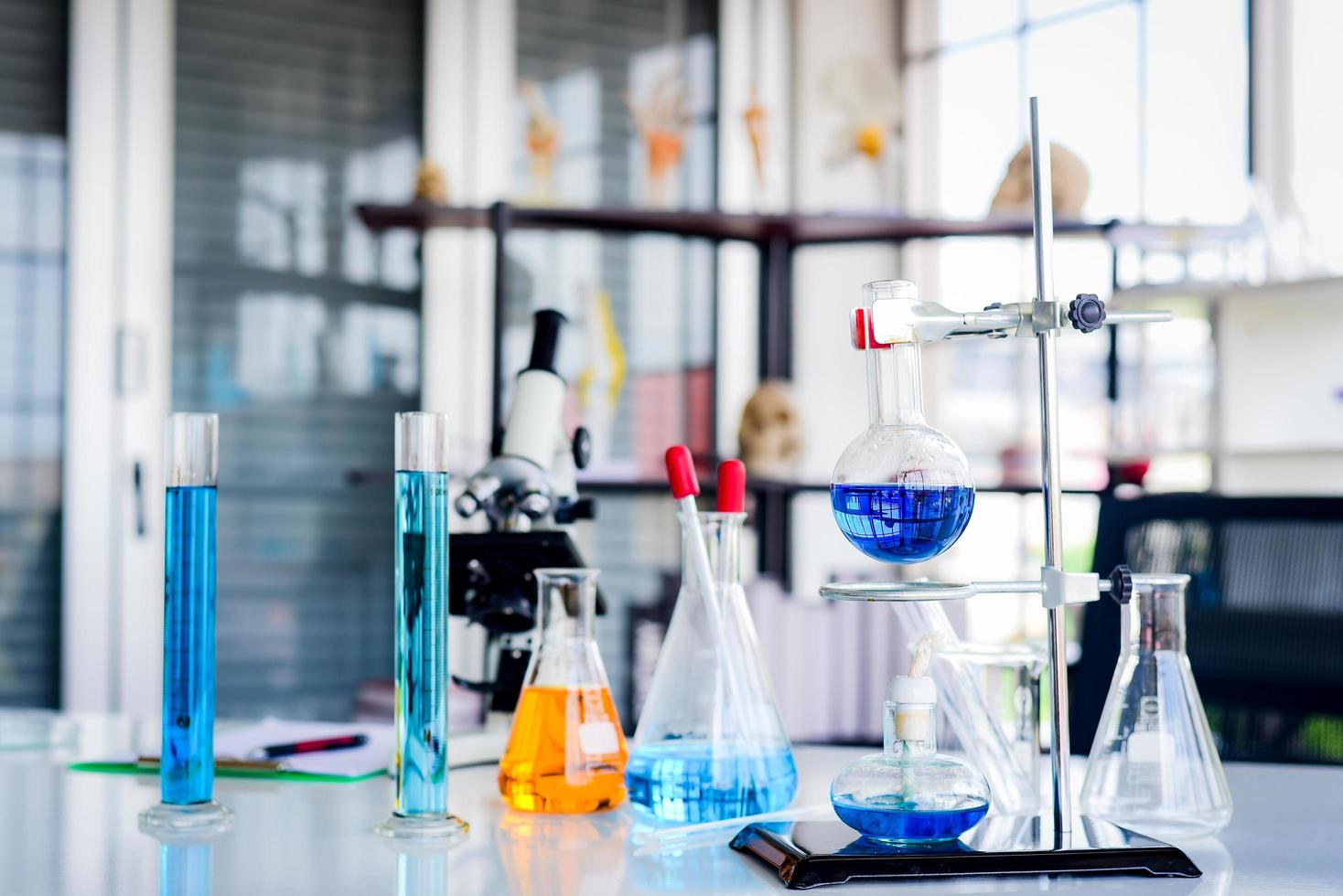 The blue chemicals in the spherical bottles were hung on standby. With the burners below With glass equipment Used for laboratory experiments such as beakers, cylinder, flask, dropper photo