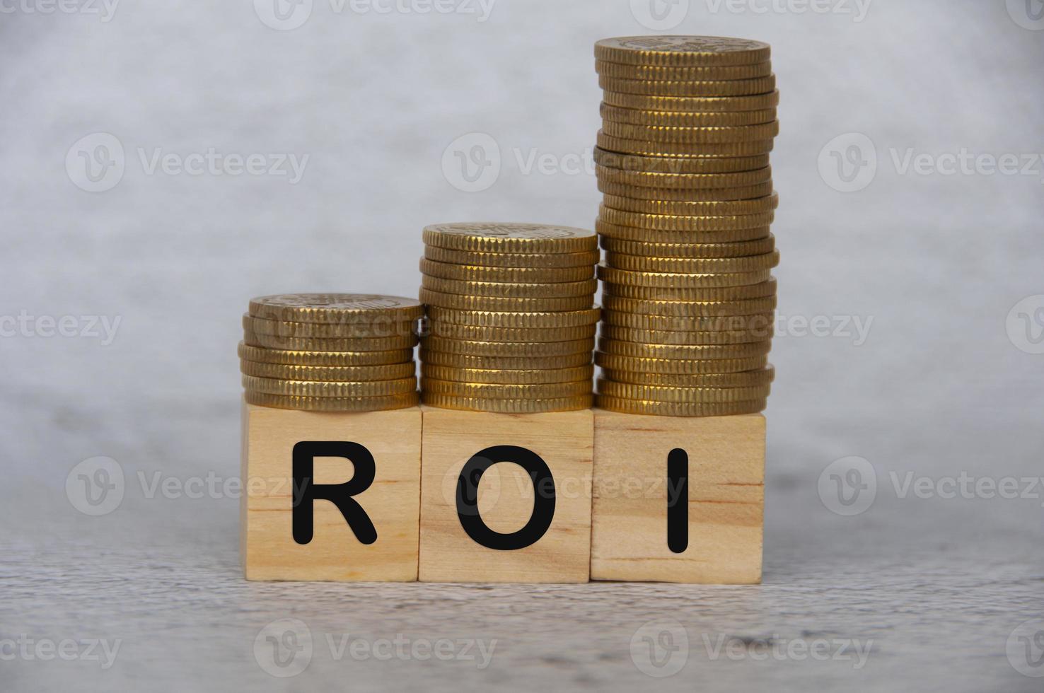 Coins stack on wooden blocks with ROI text - Business and Investment concept photo