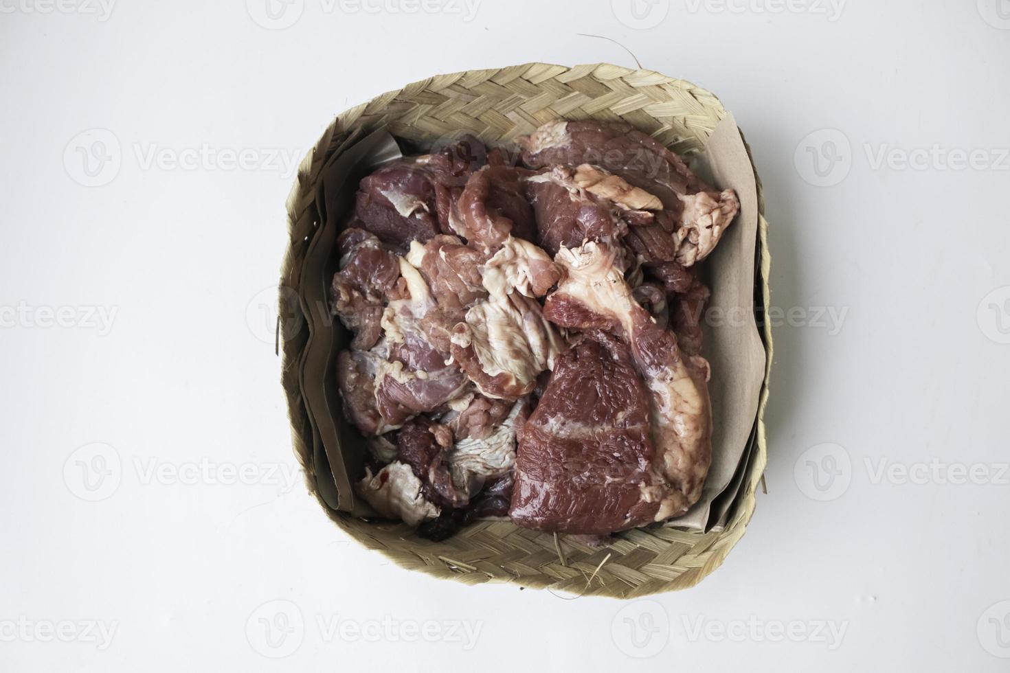 Lamb raw meat in the bamboo plate or besek at the Feast of Qurban during Eid Al Adha Al Mubarak isolated on white background. photo