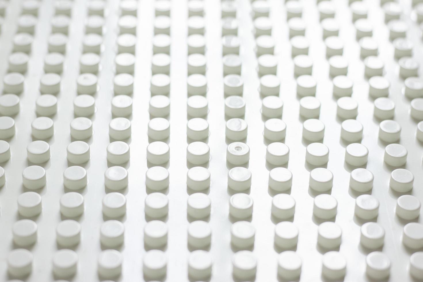 Diagonal view of a large number of neatly arranged plastic buttons cylinder for background. photo