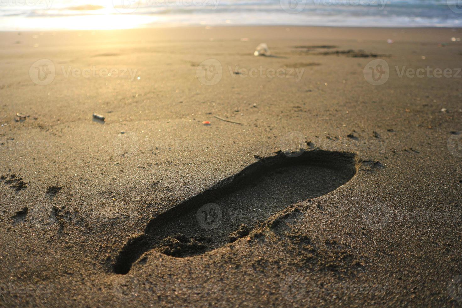 Human footprint on sand summer tropical beach at sunrise background with copyspace. photo