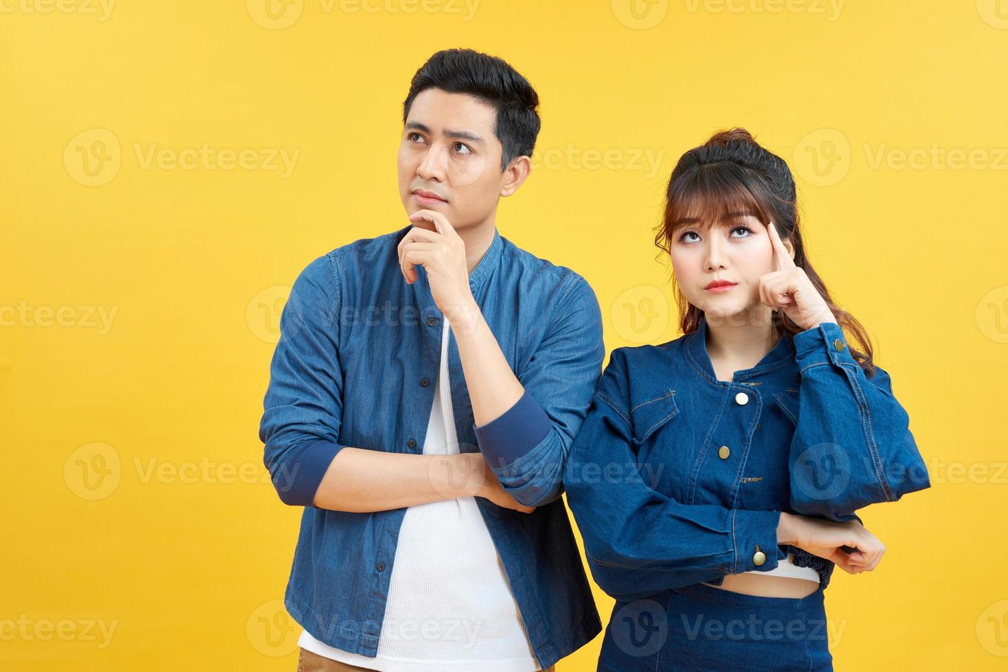 Portrait of his he her she nice attractive lovely curious bewildered couple thinking creating solution learning isolated over yellow color backgroun photo