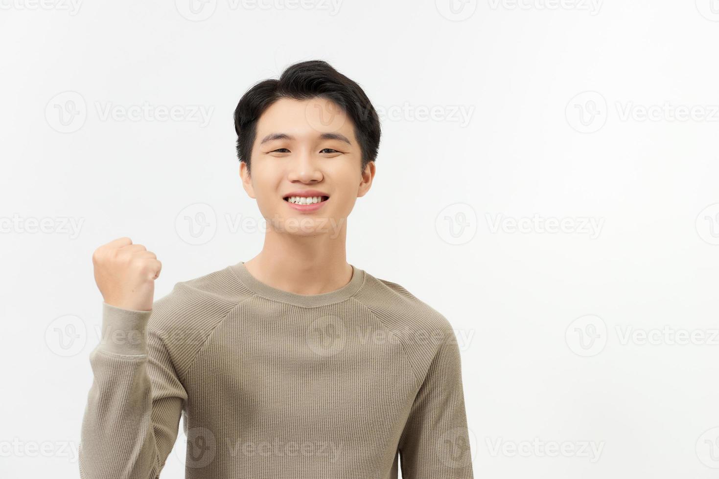 Happy excited Asian man raising his arm up to celebrate success photo