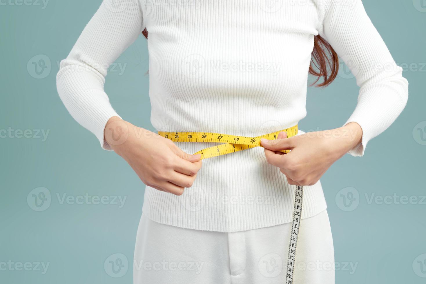 concepto de dieta, deporte y salud - hermosa mujer deportiva con cinta métrica foto